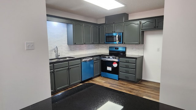 kitchen featuring sink, backsplash, stainless steel appliances, wood-type flooring, and a textured ceiling