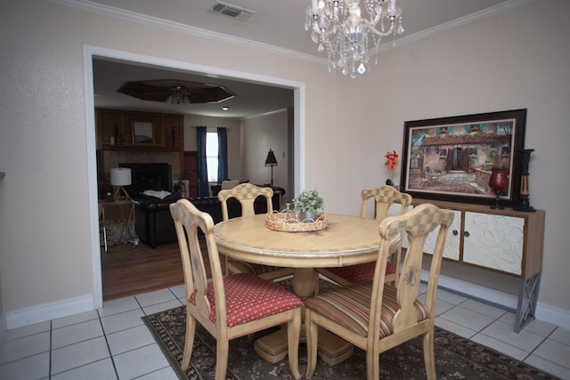 dining space with light tile patterned flooring, ornamental molding, and an inviting chandelier