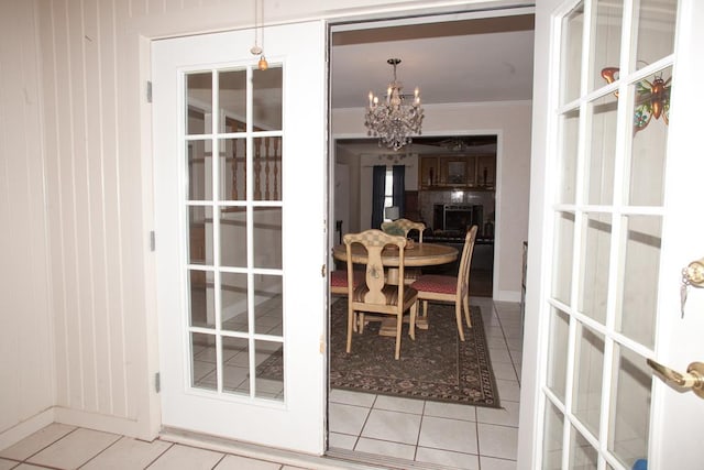 dining room featuring ornamental molding, a notable chandelier, tile patterned floors, and french doors