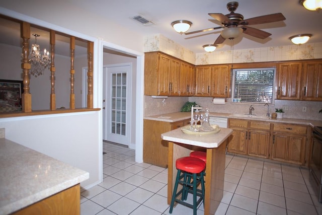 kitchen with light tile patterned floors, sink, a center island, and a kitchen bar