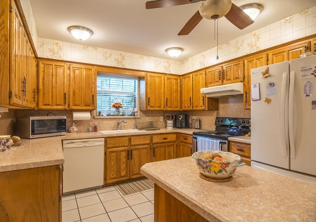 kitchen featuring tasteful backsplash, sink, light tile patterned floors, ceiling fan, and stainless steel appliances