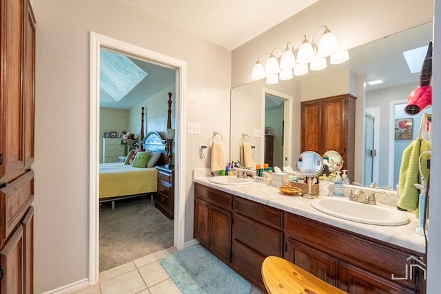 bathroom with tile patterned flooring, vanity, a skylight, and a shower with door