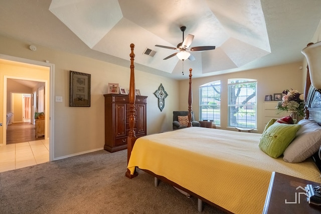 carpeted bedroom with a tray ceiling and ceiling fan