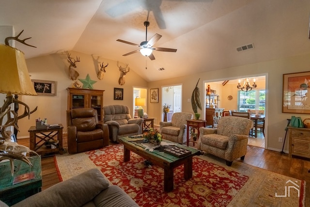 living room featuring lofted ceiling, hardwood / wood-style floors, and ceiling fan with notable chandelier