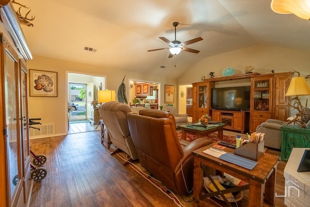 living room featuring dark wood-type flooring, vaulted ceiling, and ceiling fan