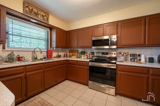 kitchen with backsplash, stainless steel appliances, sink, and light tile patterned floors