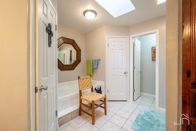 hallway with a skylight and light tile patterned flooring