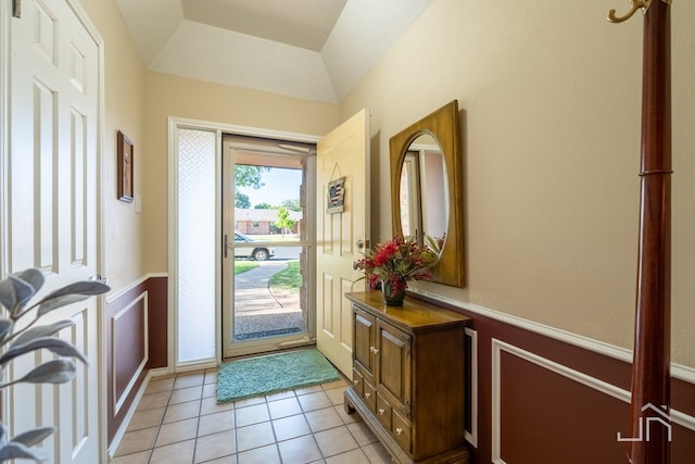 doorway to outside with lofted ceiling and light tile patterned floors