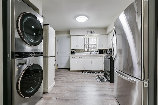 interior space featuring sink, light hardwood / wood-style floors, and stacked washer / dryer