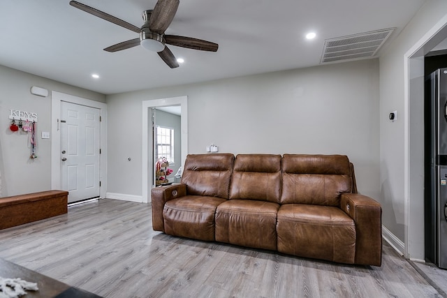 living room with light hardwood / wood-style flooring and ceiling fan