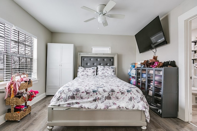 bedroom featuring hardwood / wood-style flooring, ceiling fan, and ensuite bath