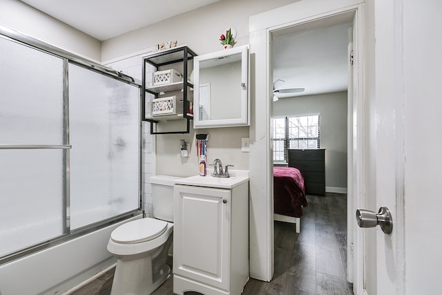 full bathroom with toilet, wood-type flooring, bath / shower combo with glass door, vanity, and ceiling fan