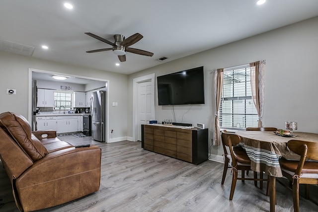 living room featuring ceiling fan, sink, and light hardwood / wood-style floors