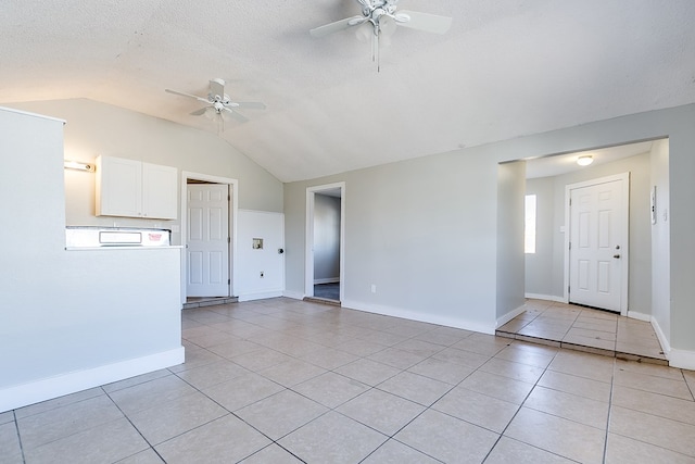 unfurnished living room with vaulted ceiling, light tile patterned flooring, a textured ceiling, and ceiling fan