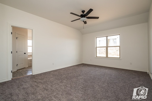 unfurnished room featuring plenty of natural light, vaulted ceiling, carpet, and baseboards