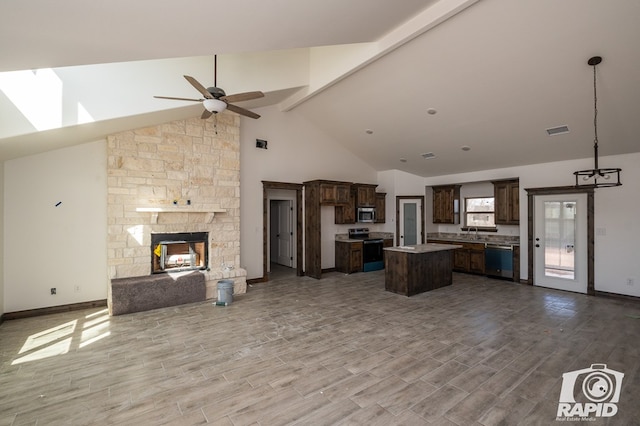 kitchen with dark brown cabinetry, visible vents, open floor plan, a center island, and stainless steel appliances