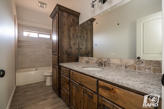 bathroom with toilet, wood tiled floor, baseboards, and vanity