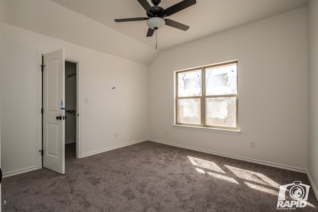 carpeted empty room featuring a ceiling fan, lofted ceiling, and baseboards