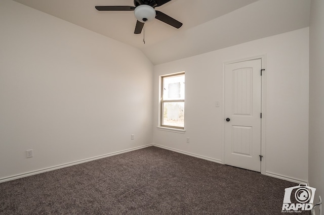 spare room featuring lofted ceiling, ceiling fan, baseboards, and dark colored carpet