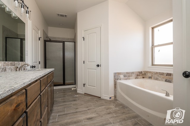 bathroom with a garden tub, vanity, visible vents, a shower stall, and wood tiled floor