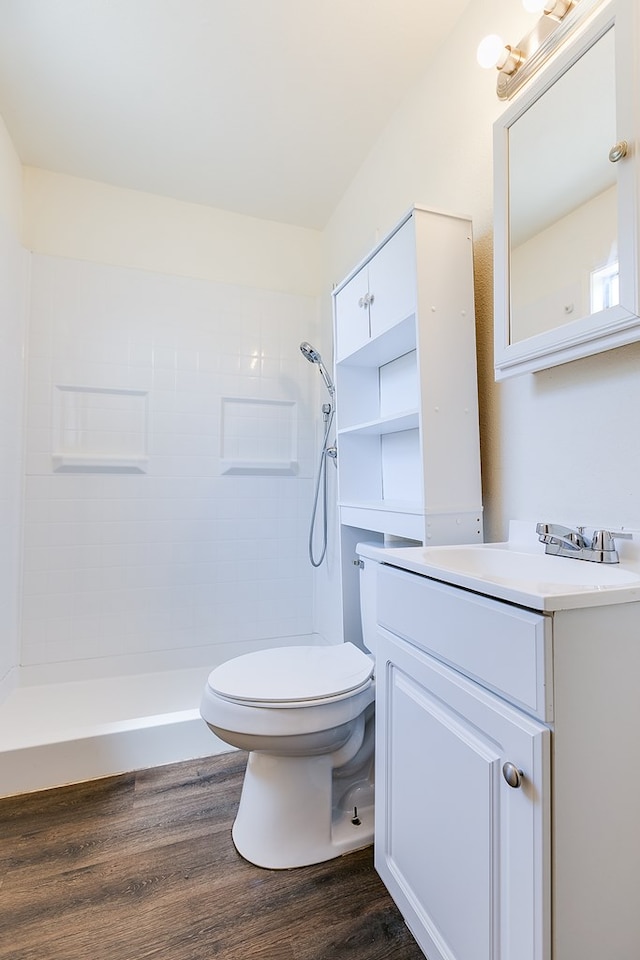 2113 S Hill St, San Angelo, TX 76903 - full bath featuring vanity, a tile shower, toilet, and wood finished floors