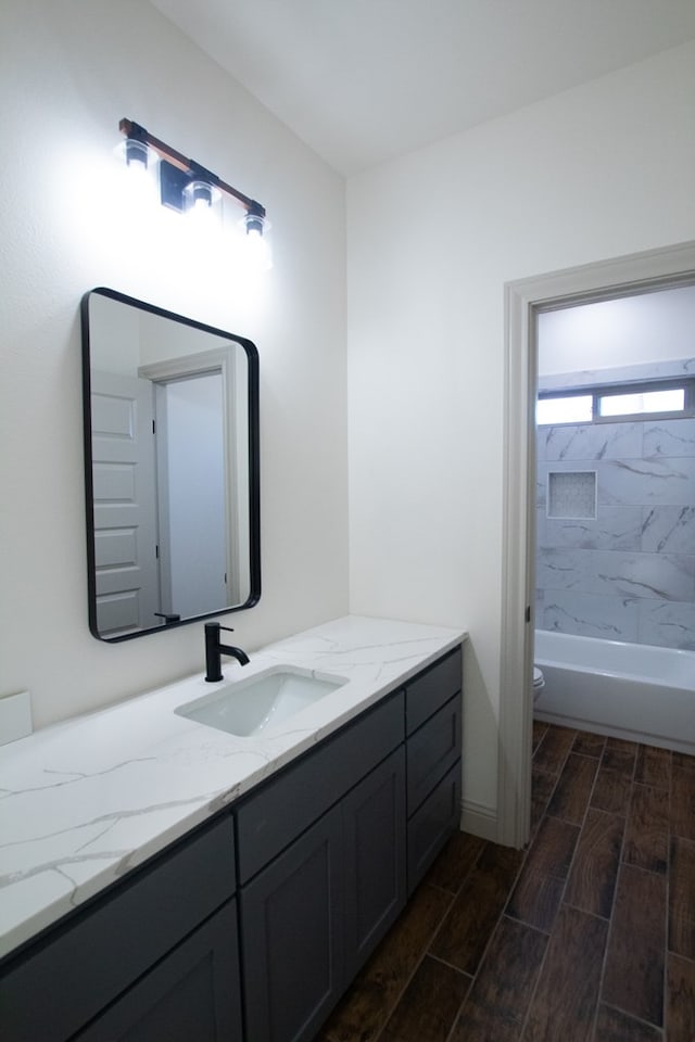 9614 Bighorn Trl, San Angelo, TX 76901 - bathroom with wood tiled floors, vanity, toilet, and tub / shower combination