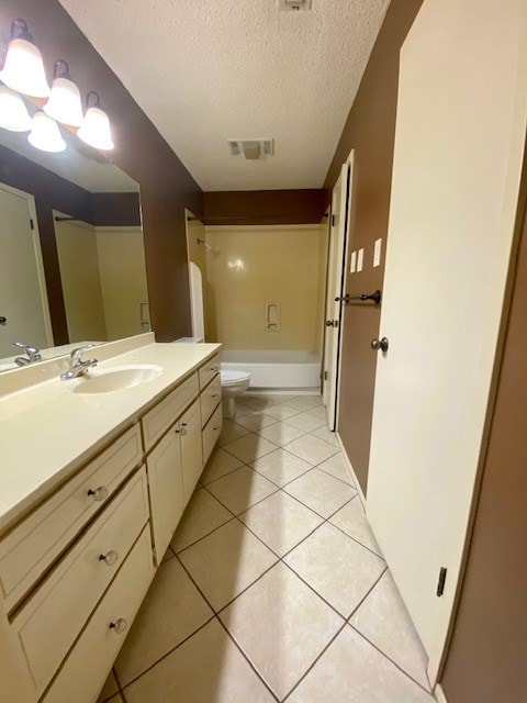 full bath featuring a textured ceiling, tile patterned flooring, toilet, vanity, and washtub / shower combination