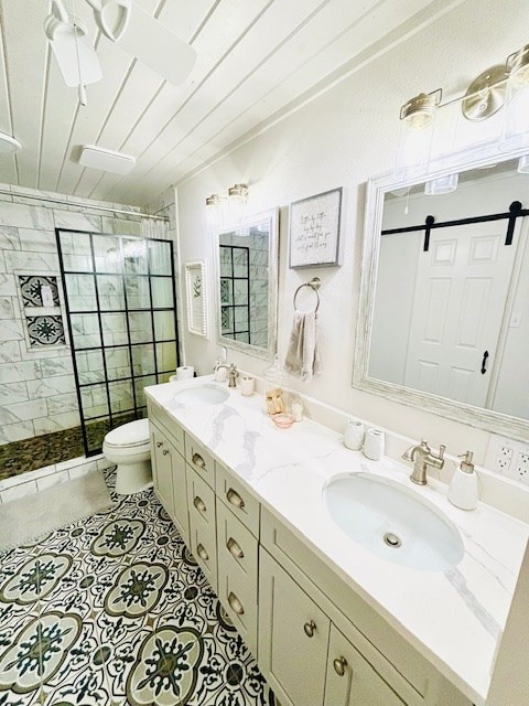 full bathroom with double vanity, a sink, toilet, and a shower stall