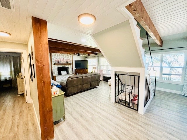 living room featuring light wood-type flooring, wood ceiling, baseboards, and beam ceiling