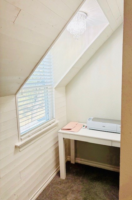 carpeted office space with vaulted ceiling