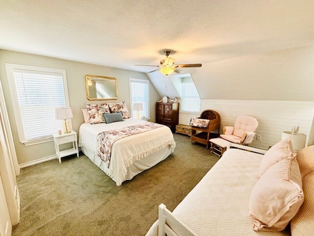 carpeted bedroom featuring a ceiling fan, a textured ceiling, and lofted ceiling