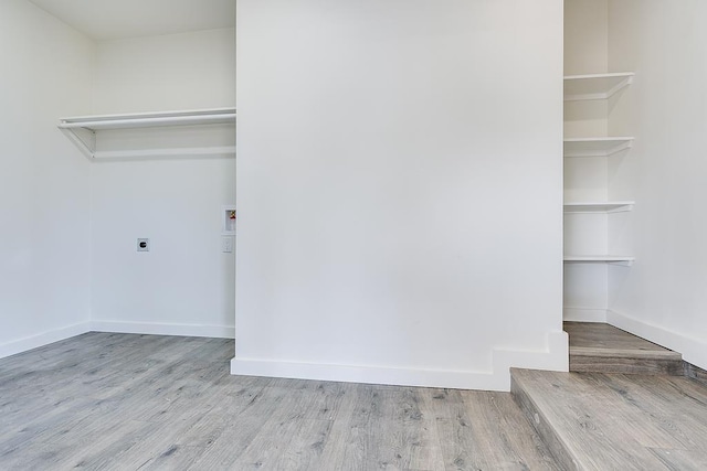 interior space with hookup for an electric dryer, hookup for a washing machine, and light hardwood / wood-style flooring