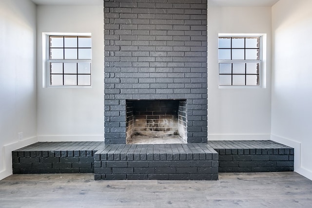 interior details featuring hardwood / wood-style flooring and a brick fireplace