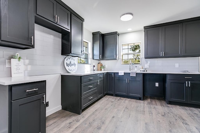 kitchen with sink, backsplash, and light hardwood / wood-style floors