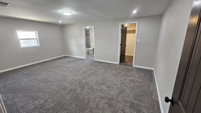 2514 S Hill St, San Angelo, TX 76903 - unfurnished bedroom with dark colored carpet, visible vents, ensuite bathroom, baseboards, and a spacious closet