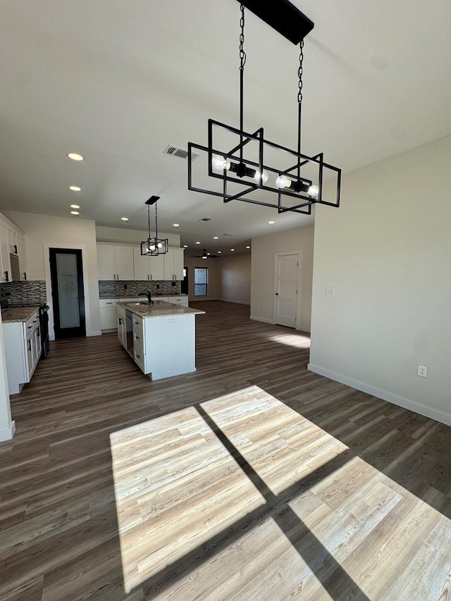 kitchen featuring backsplash, a chandelier, white cabinetry, open floor plan, and visible vents