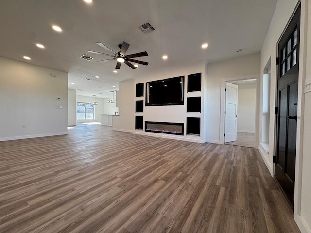 unfurnished living room featuring a ceiling fan, recessed lighting, wood finished floors, and visible vents