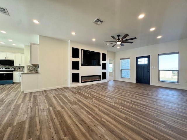 unfurnished living room with visible vents, recessed lighting, a ceiling fan, and wood finished floors