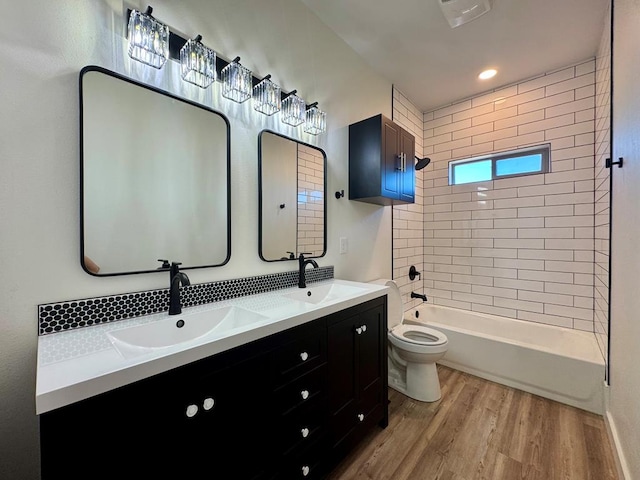 full bathroom featuring double vanity, a sink, toilet, and wood finished floors