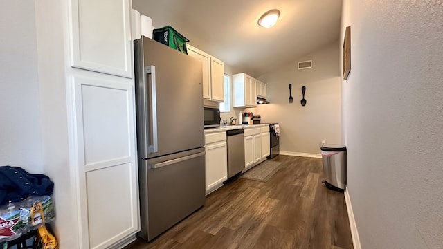 kitchen with dark wood-type flooring, appliances with stainless steel finishes, ventilation hood, white cabinets, and vaulted ceiling