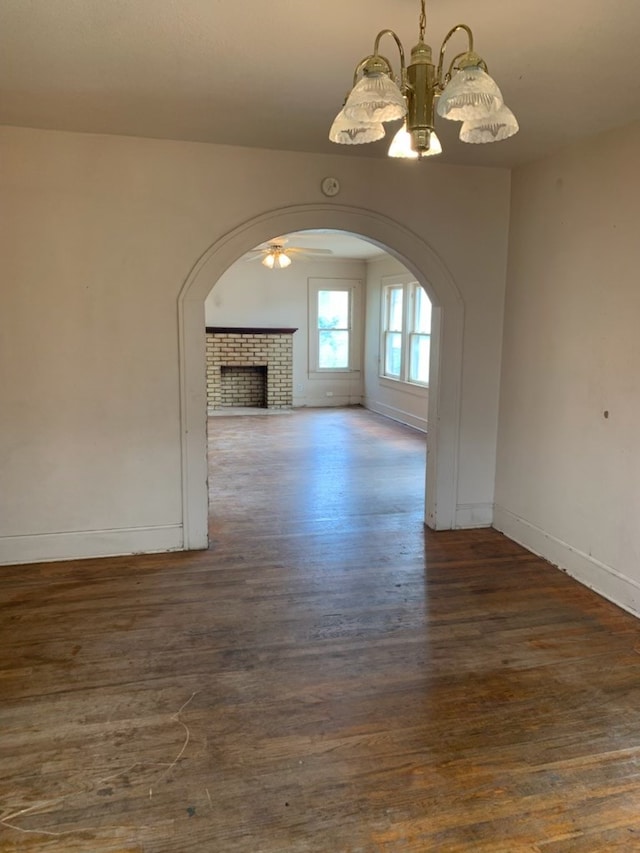 606 Pulliam St, San Angelo, TX 76903 - unfurnished living room featuring a chandelier, baseboards, wood finished floors, arched walkways, and a ceiling fan