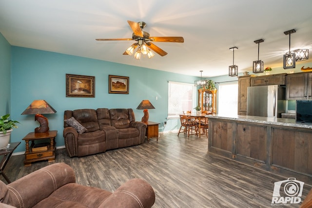 living room with dark wood finished floors, a ceiling fan, and baseboards