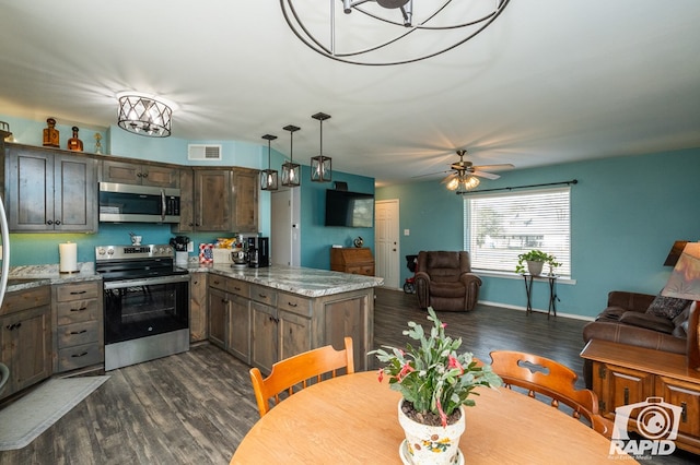 kitchen featuring visible vents, a peninsula, stainless steel appliances, dark wood-type flooring, and open floor plan