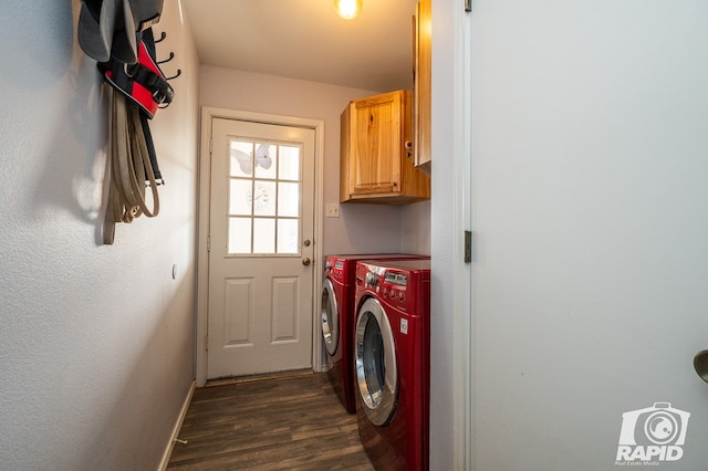 laundry area with dark wood-type flooring, washing machine and dryer, cabinet space, and baseboards