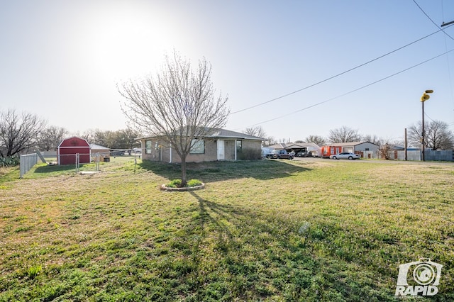 view of yard with an outdoor structure and fence