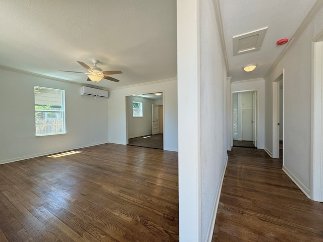 hallway with crown molding, dark wood-type flooring, an AC wall unit, and a textured ceiling