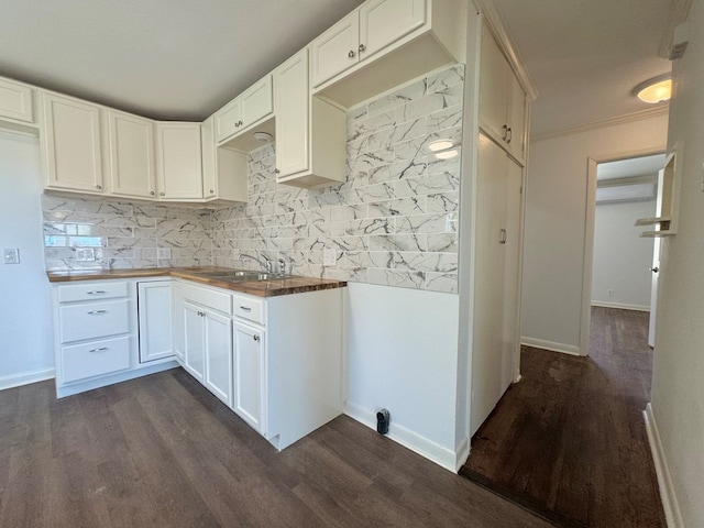 kitchen featuring butcher block counters, sink, dark wood-type flooring, and white cabinets