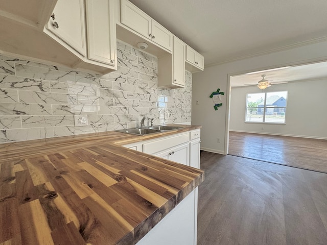 kitchen with sink, butcher block countertops, decorative backsplash, and white cabinets