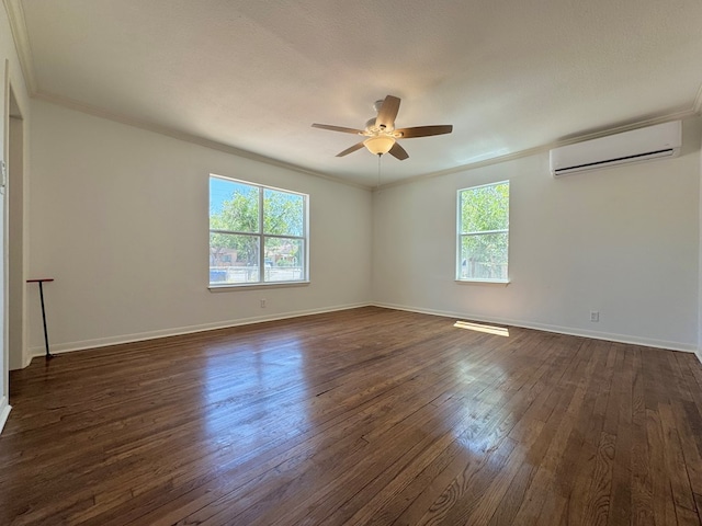 unfurnished room with dark wood-type flooring, plenty of natural light, and an AC wall unit