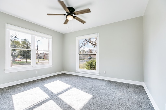 empty room featuring ceiling fan, baseboards, a wealth of natural light, and carpet flooring